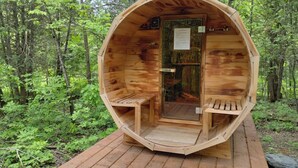 Una cabaña de madera con una puerta y dos bancos en su interior.