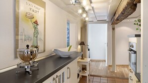 A kitchen with a black countertop, a white cabinet, a bowl, and a wall-mounted light fixture. - Apartment "Gill" with Wi-Fi (Staufen)
