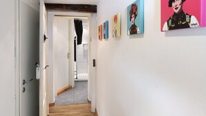 A hallway with a wooden floor, white walls, and a door leading to a bathroom. - Apartment "Gill" with Wi-Fi (Staufen)