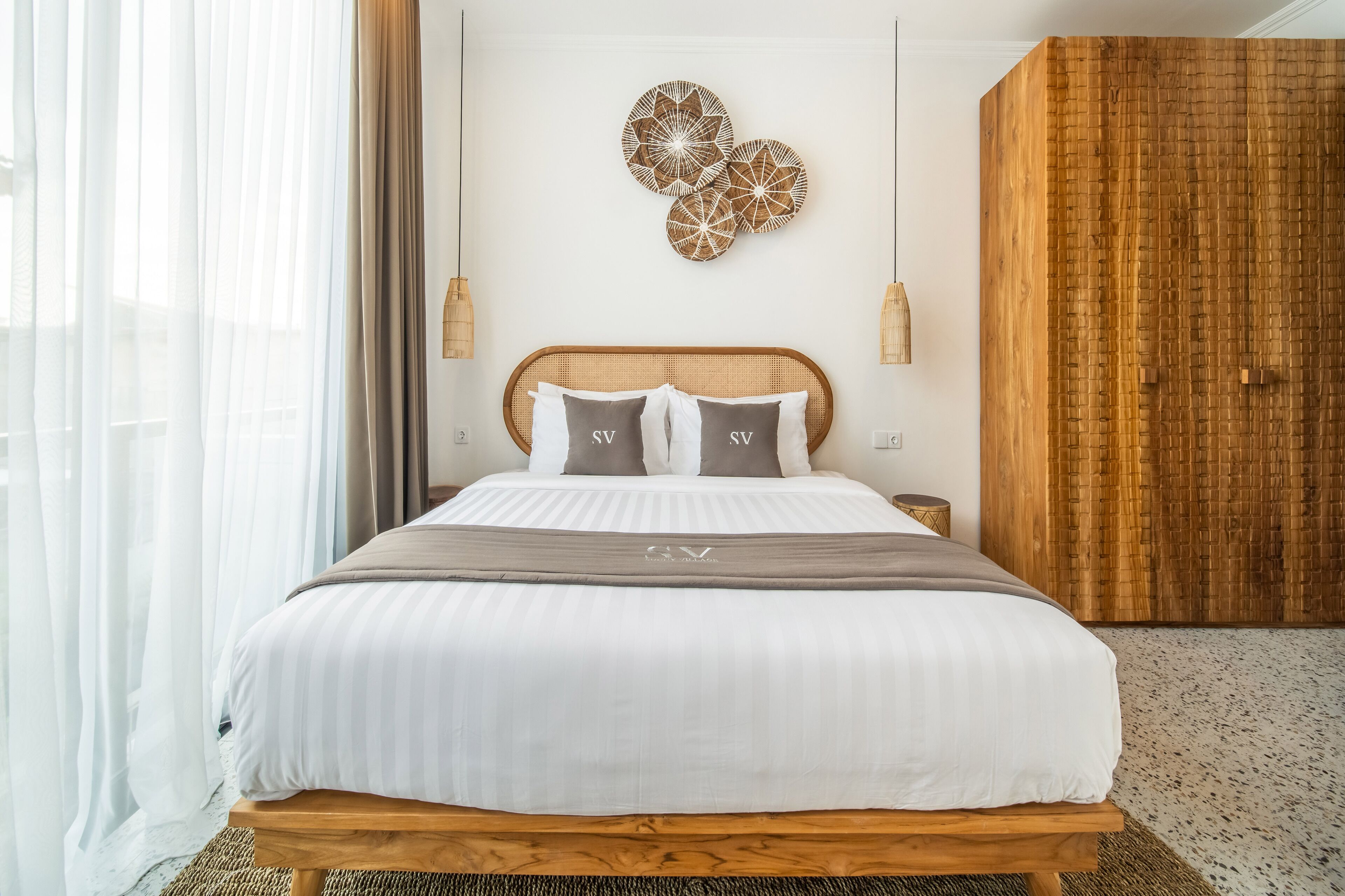 Un dormitorio moderno con una cama grande, un cabecero de madera y un adorno en la pared.