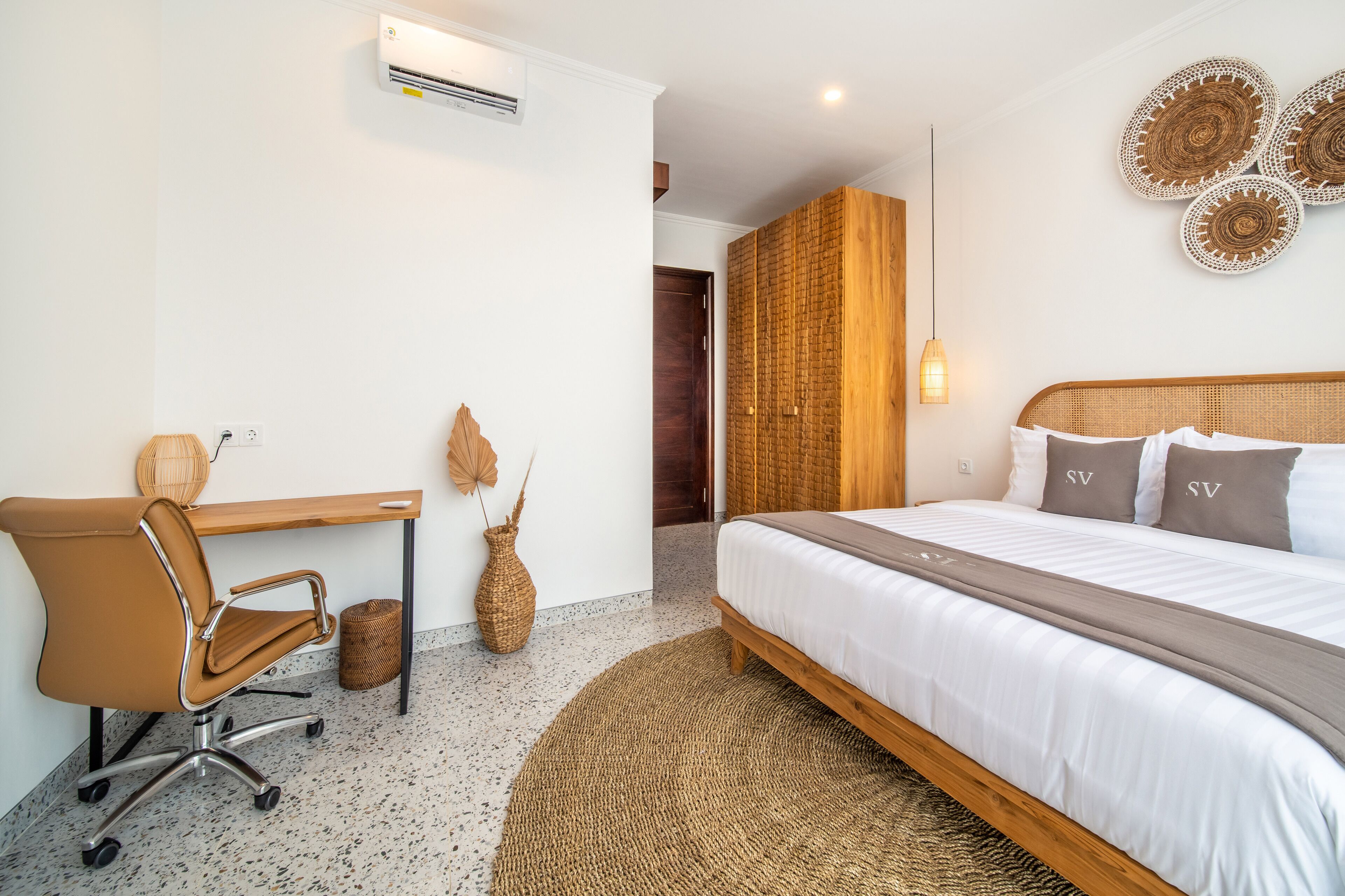 A modern hotel room with a bed, a desk, and a chair.