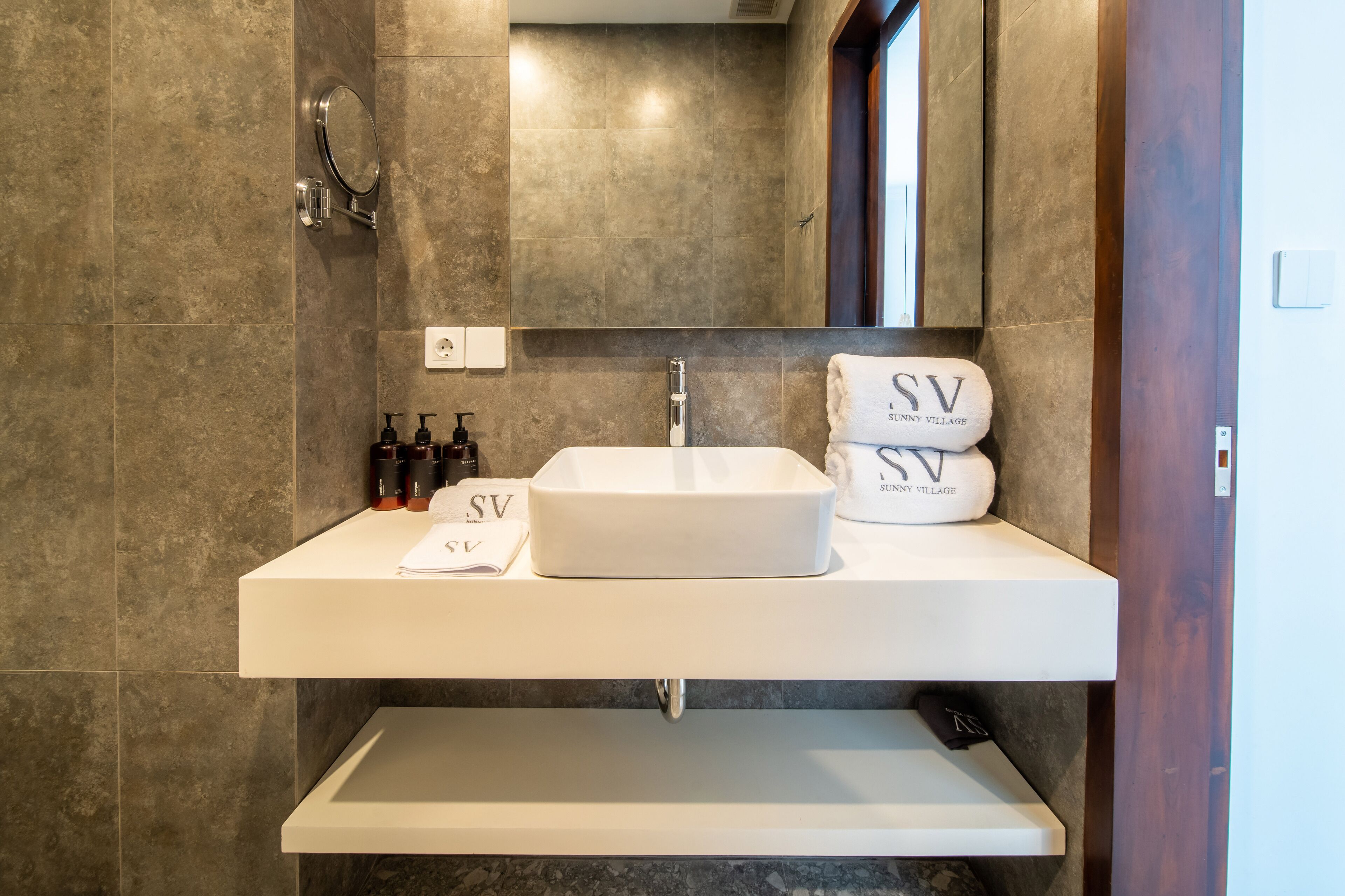 A modern bathroom with a large rectangular sink, a mirror, and a towel rack.