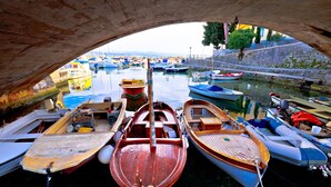 Une vue de bateaux amarrés sous un pont, avec une eau calme et un ciel dégagé.