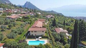Uma villa numa encosta, com piscina, rodeada por vegetação exuberante e um cenário montanhoso.