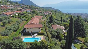 A villa with a swimming pool surrounded by lush greenery and a view of a lake and mountains. - Villetta Enzo in Toscolano Maderno (Toscolano Maderno)