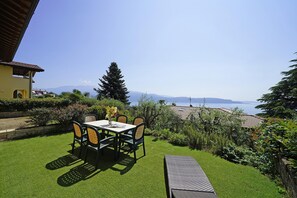 A patio with a table and chairs, a bench, and a view of the sea. - Villetta Enzo in Toscolano Maderno (Toscolano Maderno)