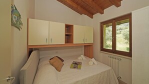 Quarto com cama, janela e teto de madeira.