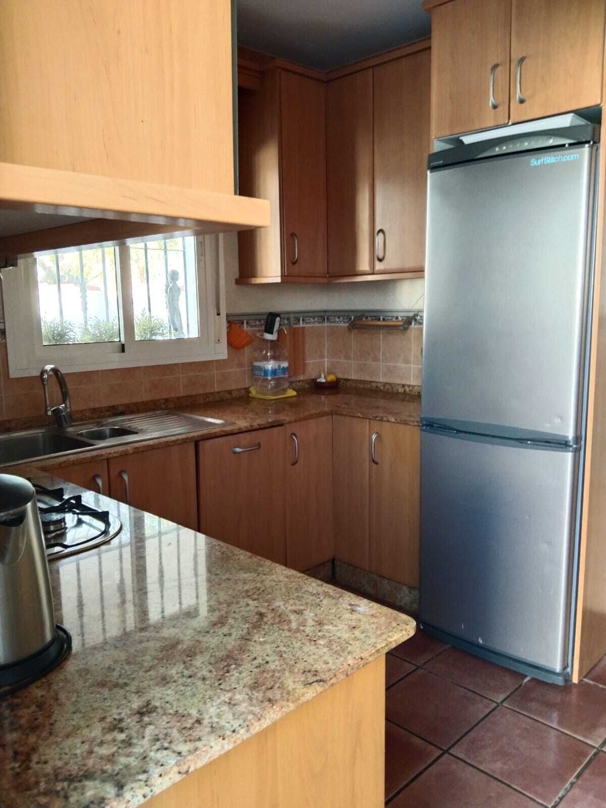 Een koffiezetapparaat/waterkoker, een koelkast, een oven, een kookplaat