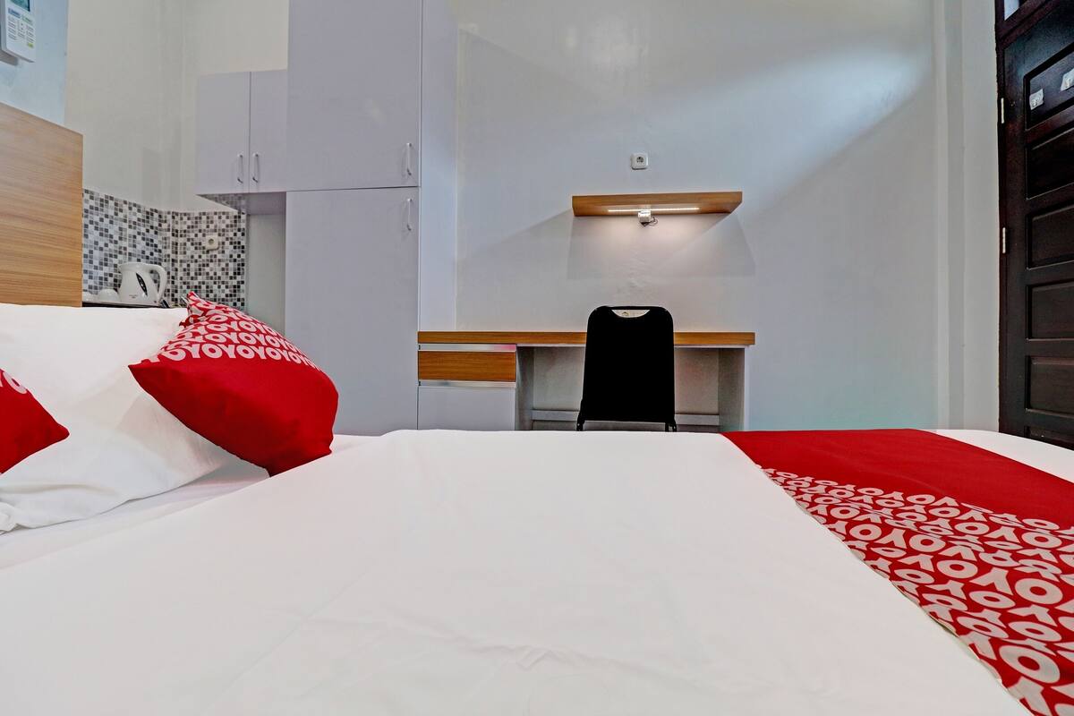 Habitació d'hotel amb un llit, una taula de treball i una cadira.