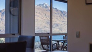 A room with large windows offering a mountain view.