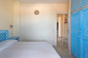 A bedroom with a bed, a nightstand, a wardrobe, and a door leading to a bathroom. - The perfect positioned Baia de Bahas Residence one Bedroom sleeps 4 - num0883 (Marinella)