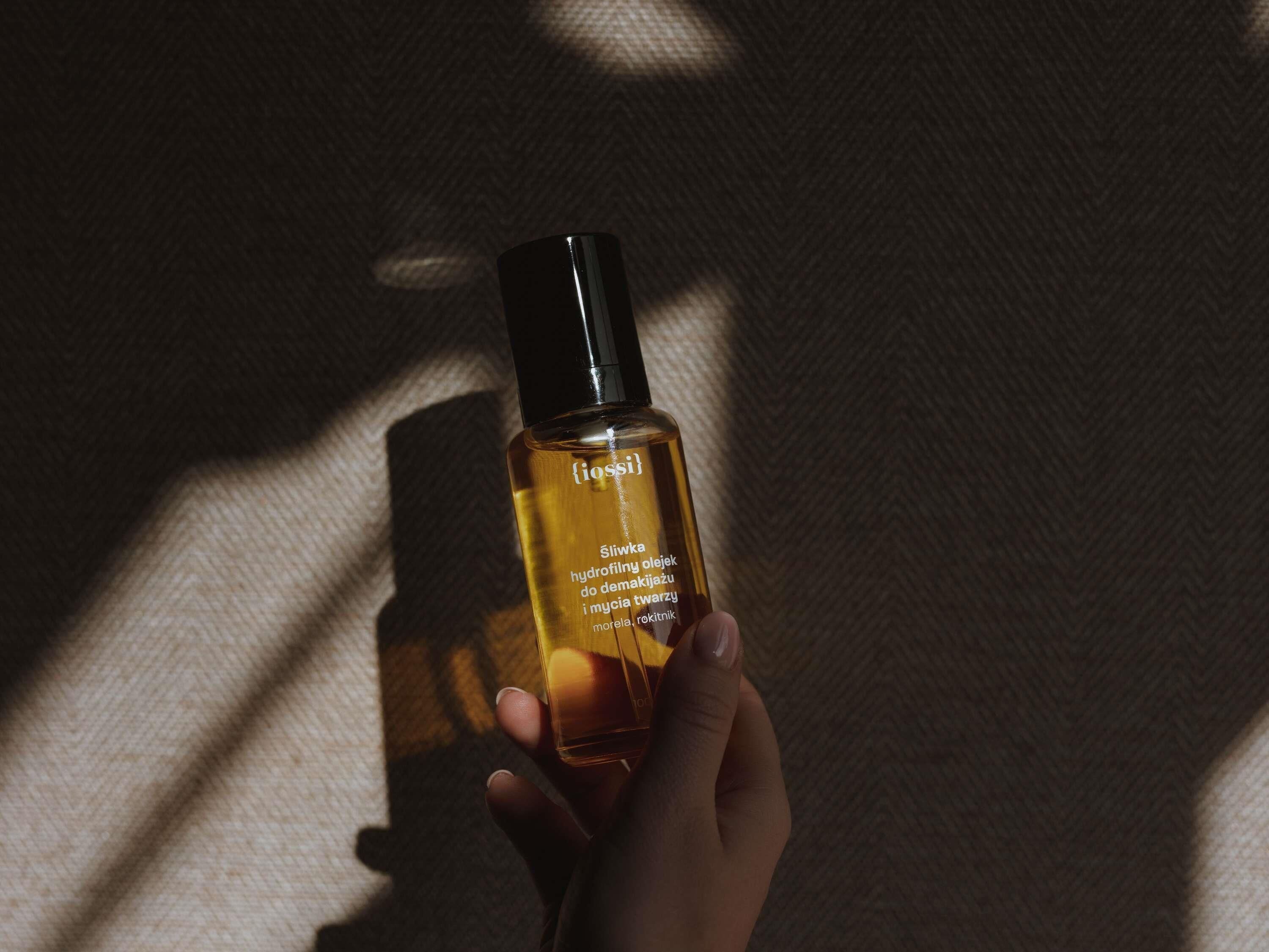 A hand holding a bottle of product with text in a foreign language.