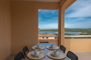 A table set for four with a view of a coastal landscape.