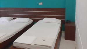 A hotel room with two single beds, a wooden headboard, and a small wooden nightstand. - Hotel Shalimar Residency (Kanayannur)