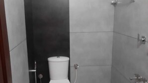A small, modern bathroom with a toilet, a shower, and a sink. - Hotel Shalimar Residency (Kanayannur)
