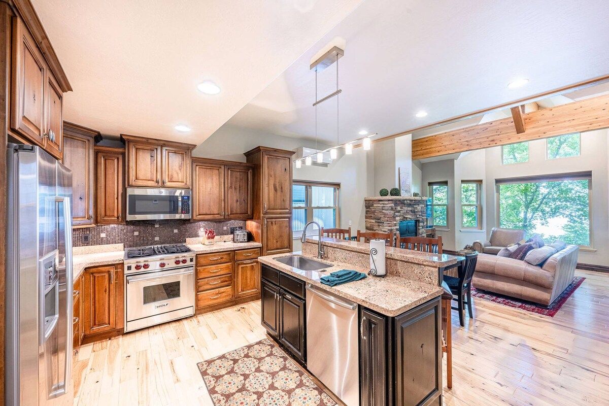 A modern kitchen with wooden cabinets, stainless steel appliances, and a central island.