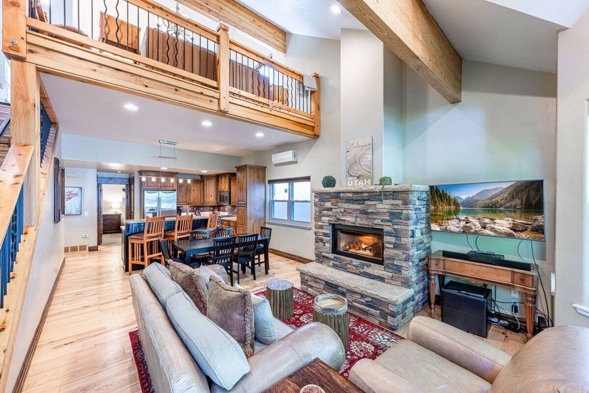 A spacious living area with a fireplace, a dining area, and a kitchen.
