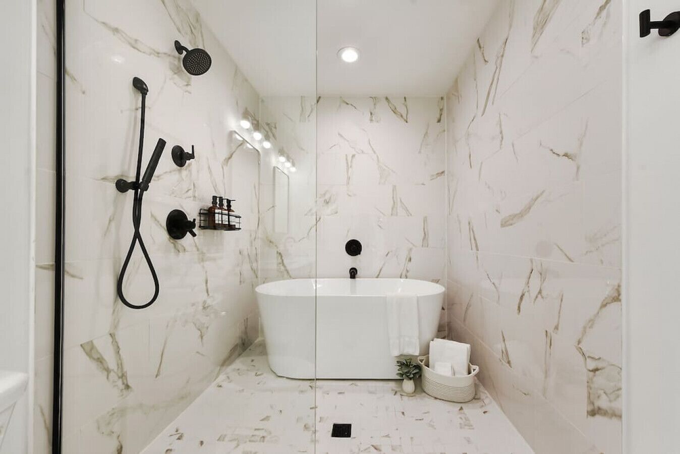 A modern bathroom with a freestanding bathtub, a handheld showerhead, and a wall-mounted faucet.