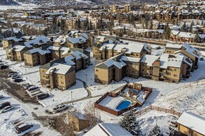 Un quartier résidentiel comprenant plusieurs immeubles d’appartements, un parking et une piscine.