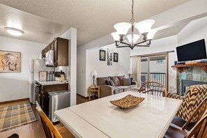 Un espace de vie compact comprenant une kitchenette, un coin repas et un coin salon.