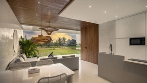 Una cocina moderna con una isla grande, electrodomésticos integrados y vistas a un paisaje exuberante.