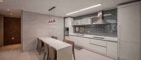 A modern kitchen with a central island, built-in appliances, and a minimalist design.