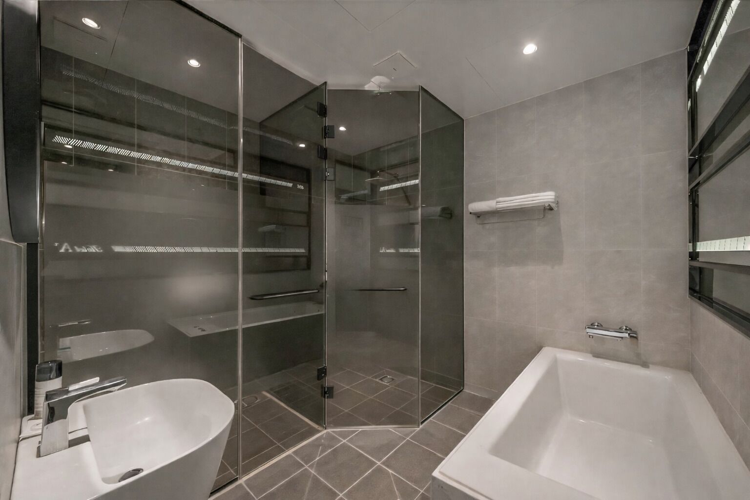 Une salle de bain moderne dotée d’une douche à parois de verre, d’une baignoire et d’un lavabo.
