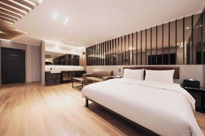 A modern hotel room with a large bed, a desk, and a kitchenette. - Pohang A1Hotel Haedo (Pohang)