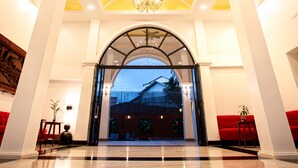 A spacious lobby with a high ceiling, a chandelier, and a view of the outside. - Solar hotel (Siem Reap)