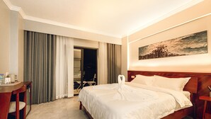 A hotel room with a bed, a desk, and a chair. There is a painting on the wall and a window with curtains. - Solar hotel (Siem Reap)
