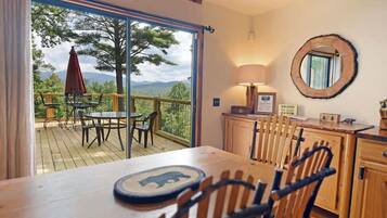 A dining area with a table, chairs, and a view of the outdoors.