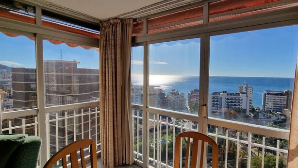 Un balcon avec vue sur la mer et les bâtiments.