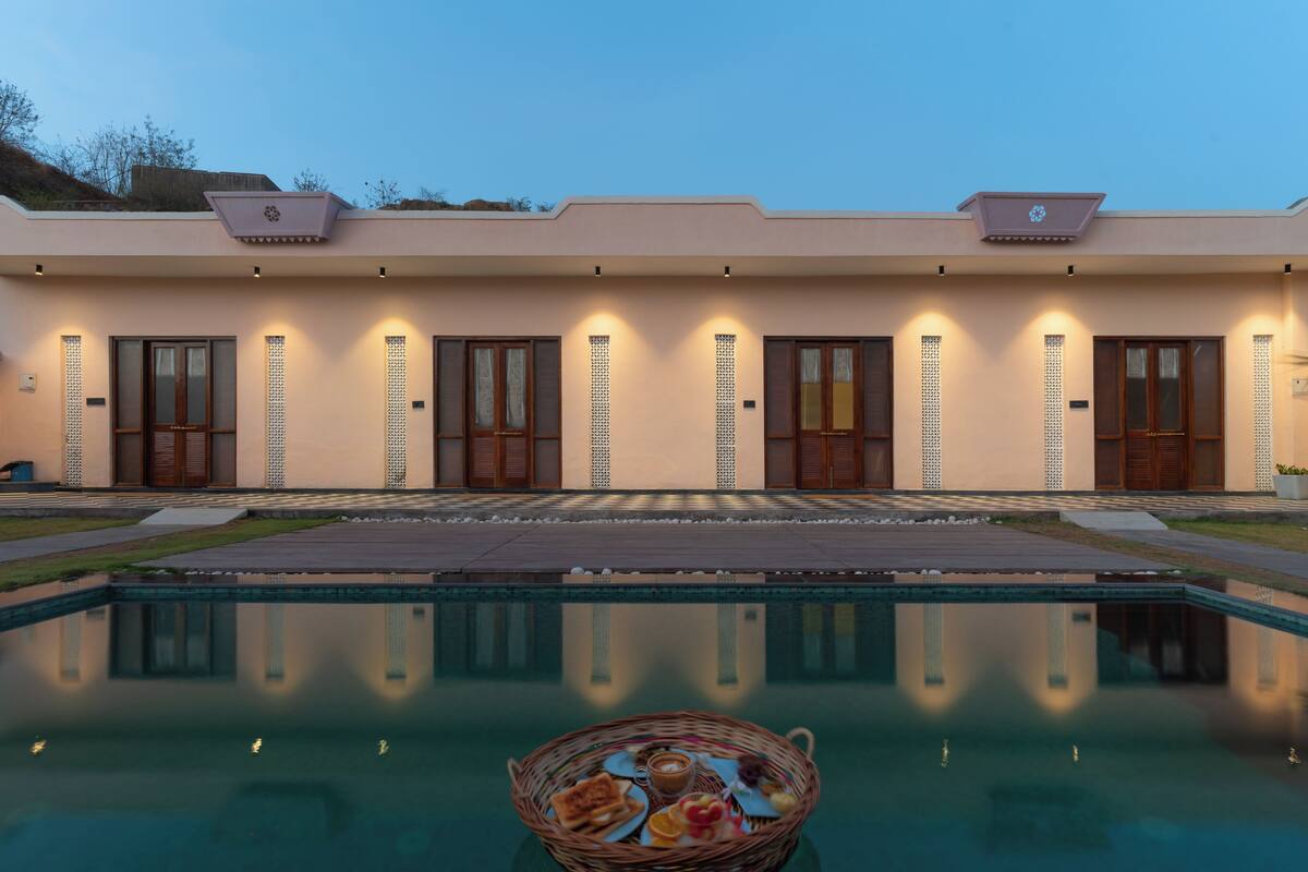 A modern building with a swimming pool in front.