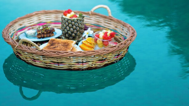 A wicker basket with food items floating on a pool's surface. - Parijat Private Pool Villa 1, 2 and 3 BHK (Udaipur)