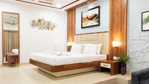 Une chambre d’hôtel moderne dotée d’un grand lit, d’un coin salon et d’un ventilateur de plafond.
