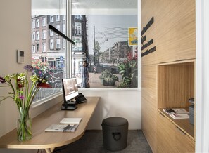 Una oficina moderna con un escritorio, computadora y ventana con vistas a la ciudad.