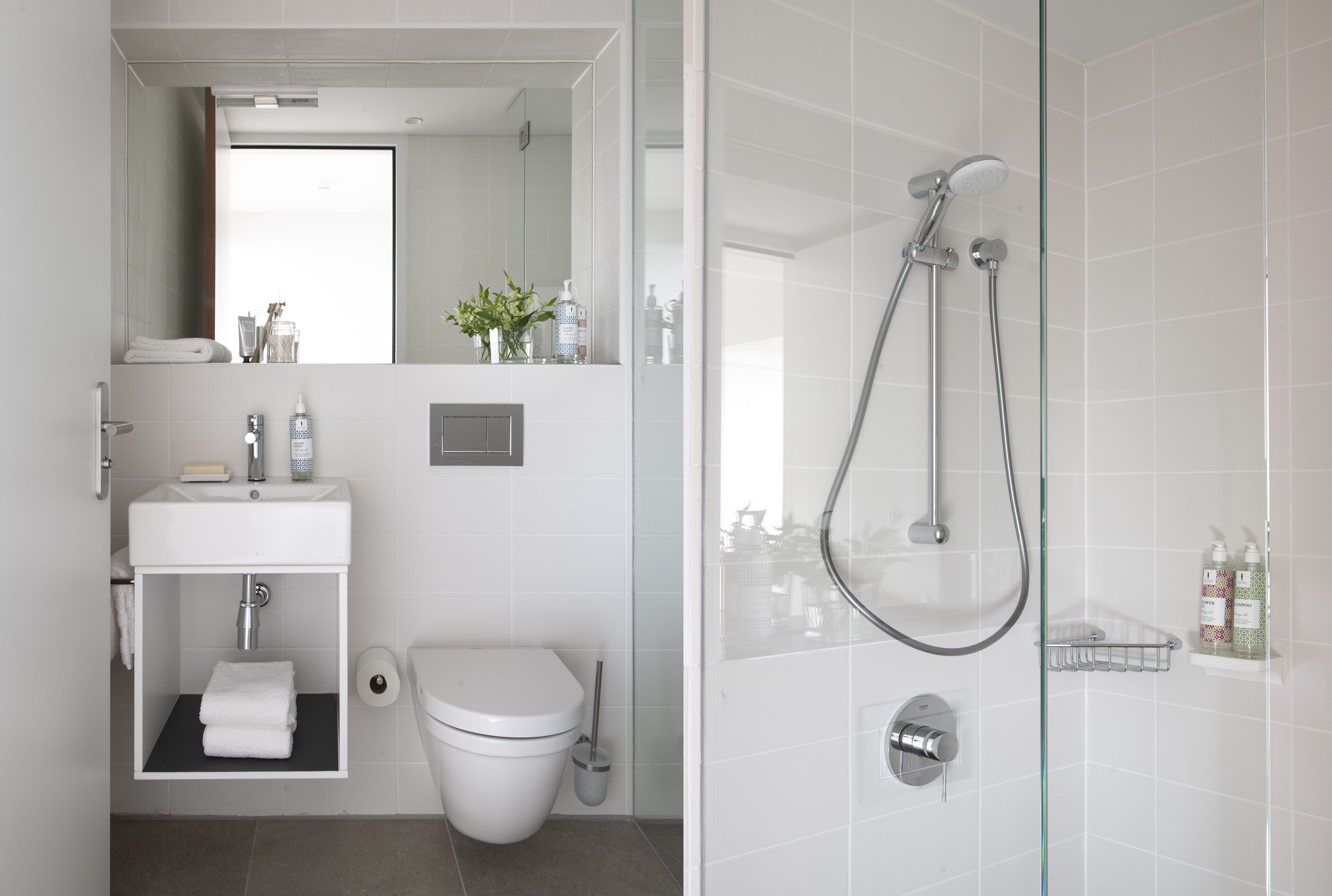 A modern bathroom with a toilet, sink, and shower.