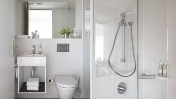 A modern bathroom with a toilet, sink, and shower.