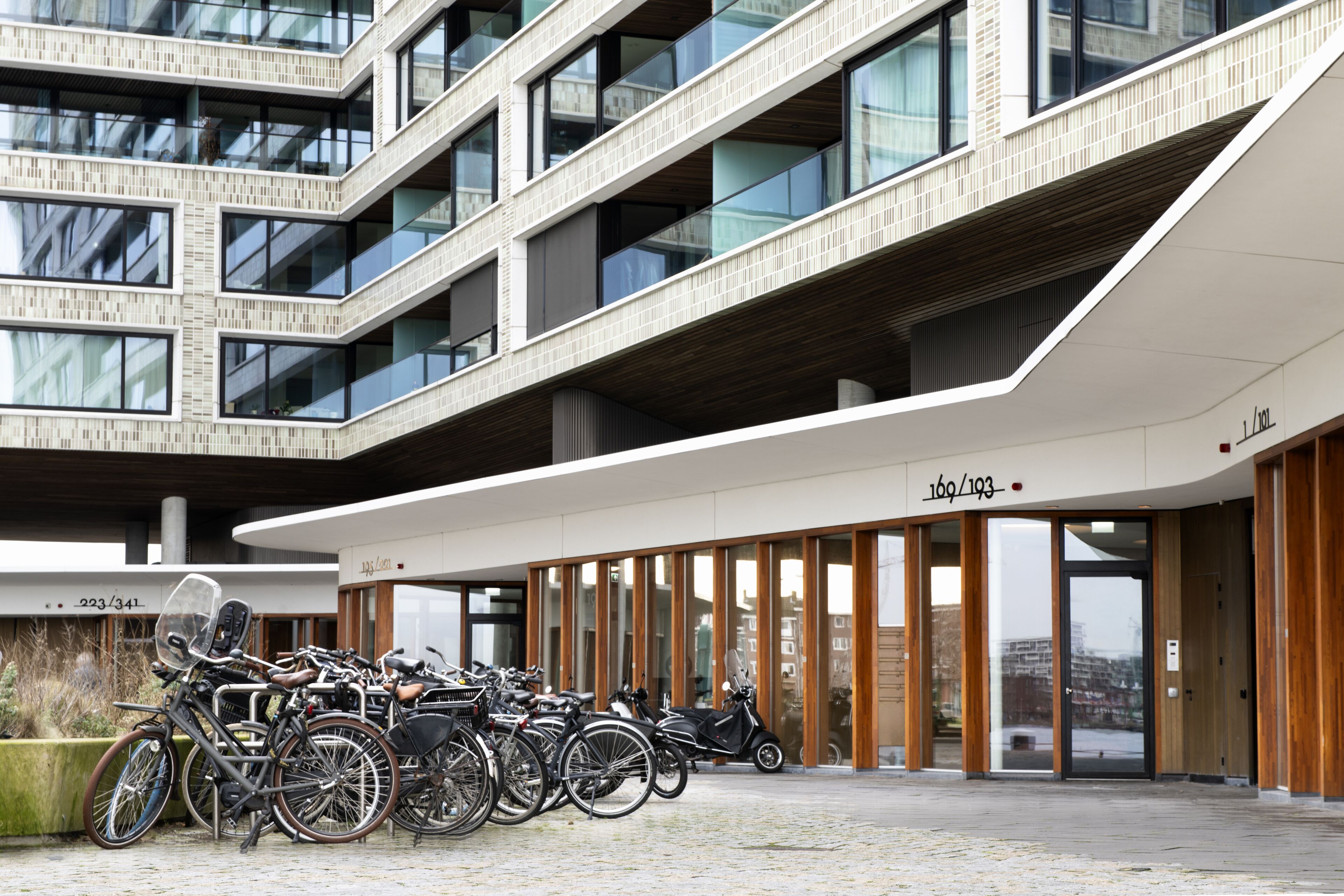 A modern building with a bike parking area in front.
