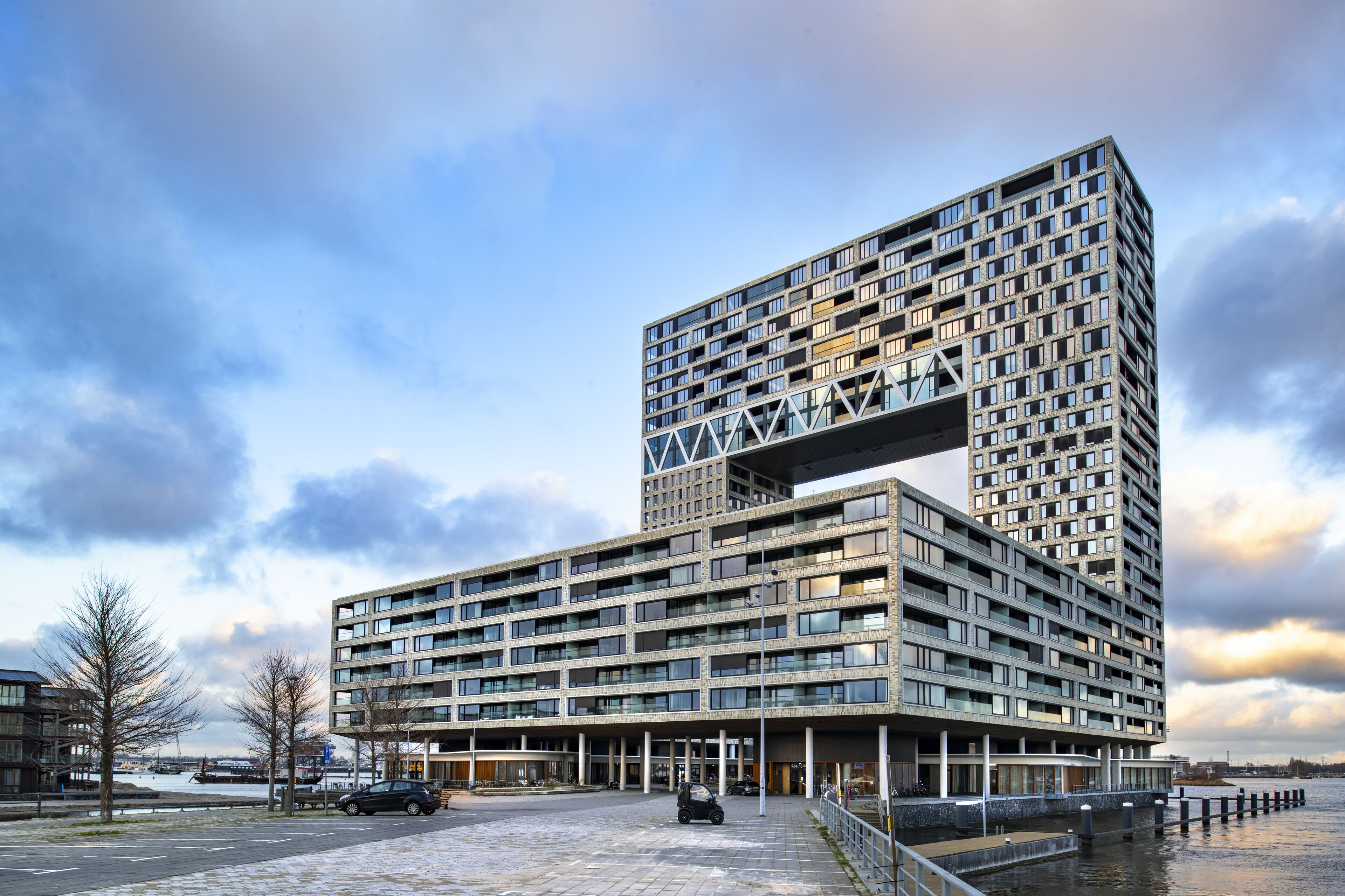Un edificio moderno de varios pisos con un diseño arquitectónico único, que destaca por un voladizo prominente.