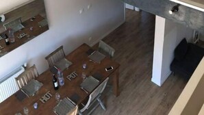 A dining area with a high table and chairs, a lower level with a balcony, and a view of the upper floor. - Maison AU Calme, Quiet House, 20 Minutes Bordeaux (Gradignan)