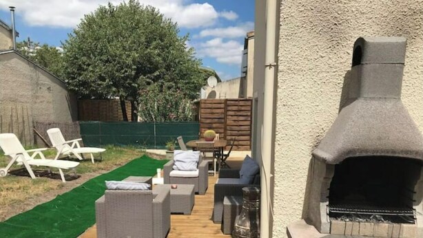 A patio with outdoor furniture, a barbecue grill, and a green lawn. - Maison AU Calme, Quiet House, 20 Minutes Bordeaux (Gradignan)
