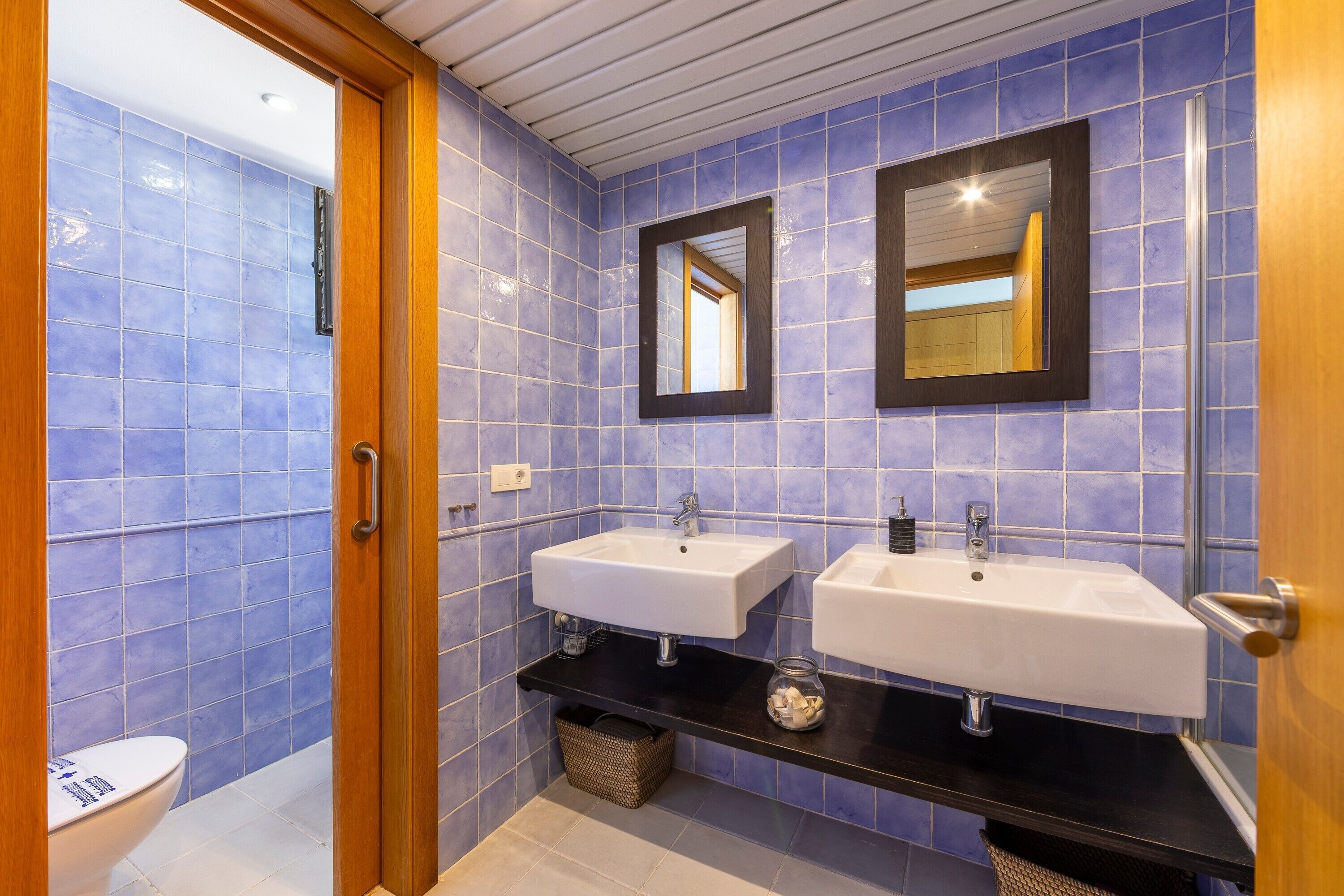 Une salle de bain avec deux lavabos, un miroir et des toilettes.