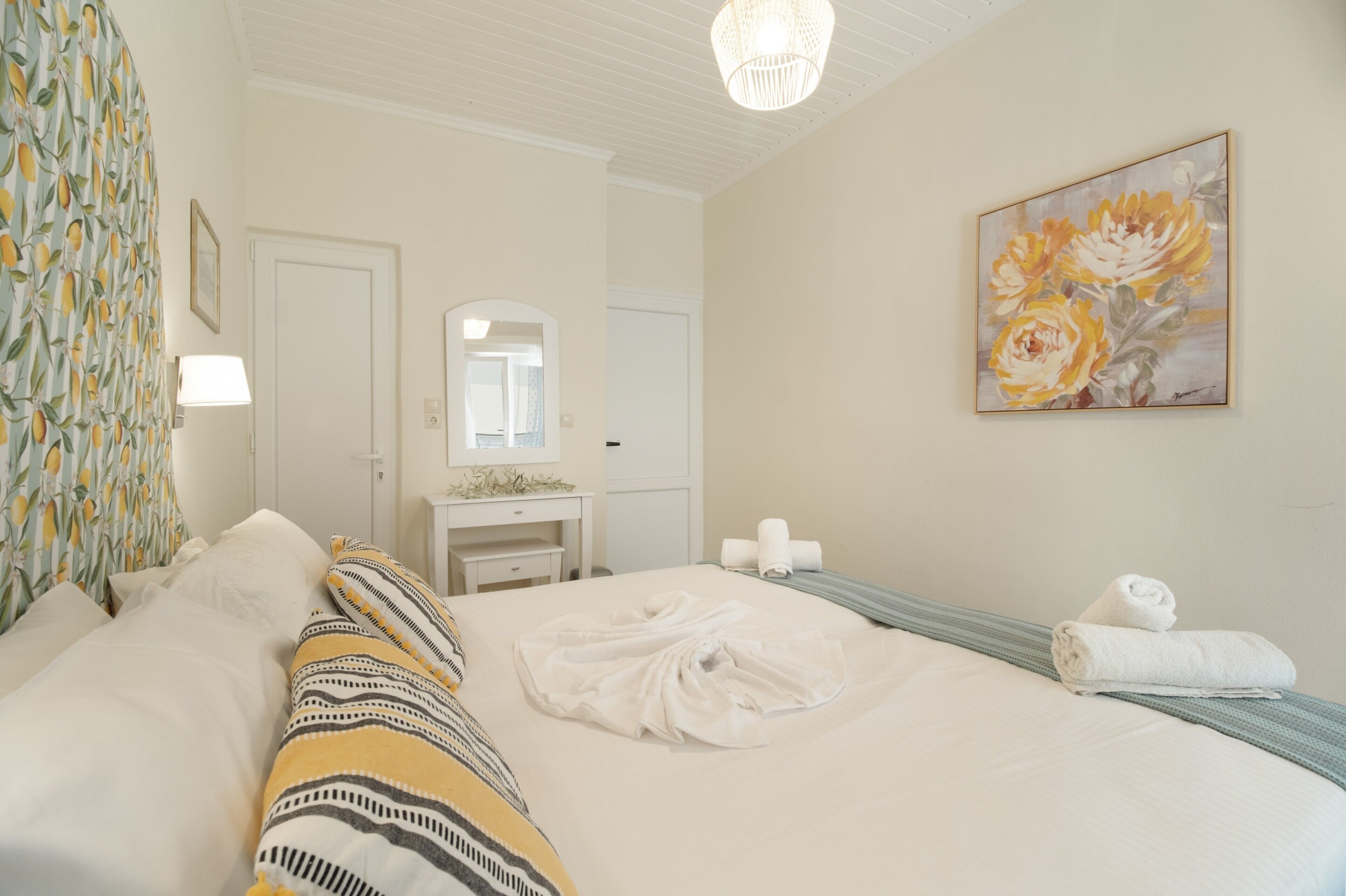 Een hotelkamer met een bed, een bureau, een spiegel, een schilderij en een lamp.