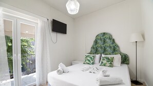 A bedroom with a bed, a TV, a balcony with a view, and a lamp. - M1 Room with Wi-Fi and Air Conditioning (Lefkada)