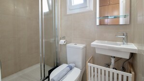 A bathroom with a glass shower enclosure, a toilet, a sink, and a mirror above the sink. - M1 Room with Wi-Fi and Air Conditioning (Lefkada)