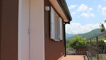 Un bâtiment doté d’un balcon, d’une porte et offrant une vue sur les montagnes.