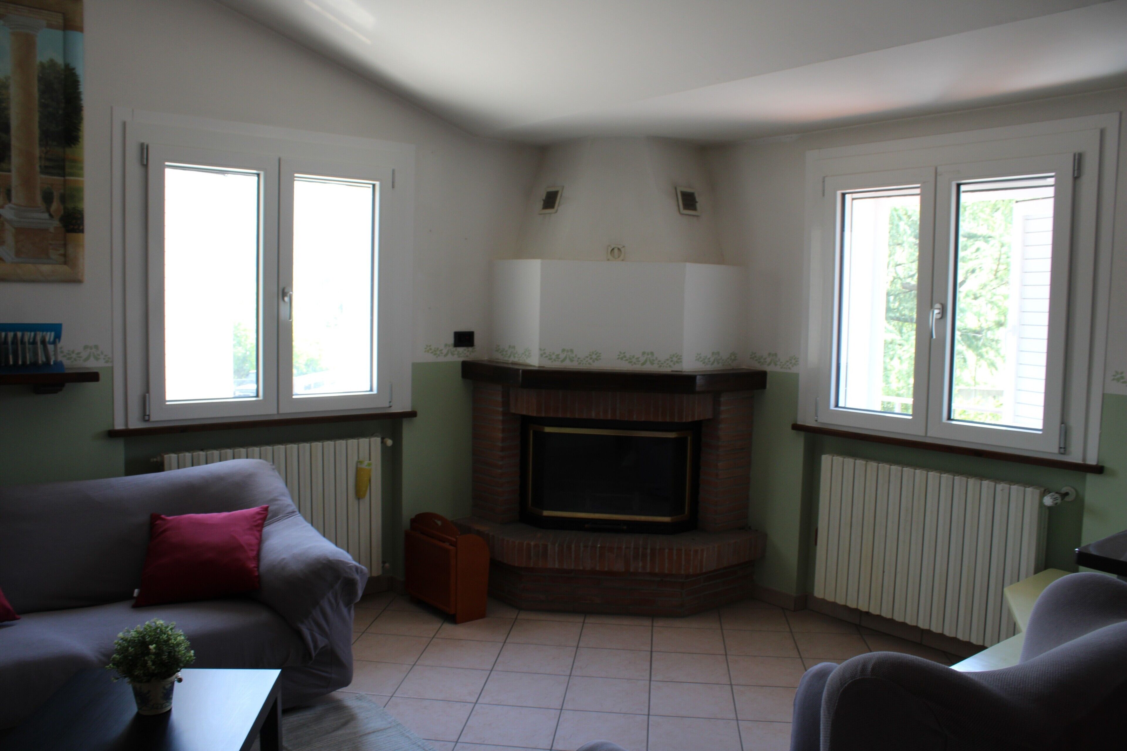 A living room with a fireplace, a sofa, a coffee table, and a window.