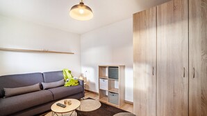 A modern living room with a sofa, coffee table, and a wardrobe. - Apartment "Unterortsgut" with Private Garden & Wi-Fi (Dorf Tirol)