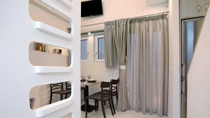 Una cocina moderna con comedor, una estantería empotrada y un televisor de pantalla plana en la pared.